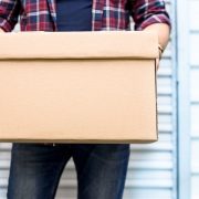 man holding box in front of storage unit
